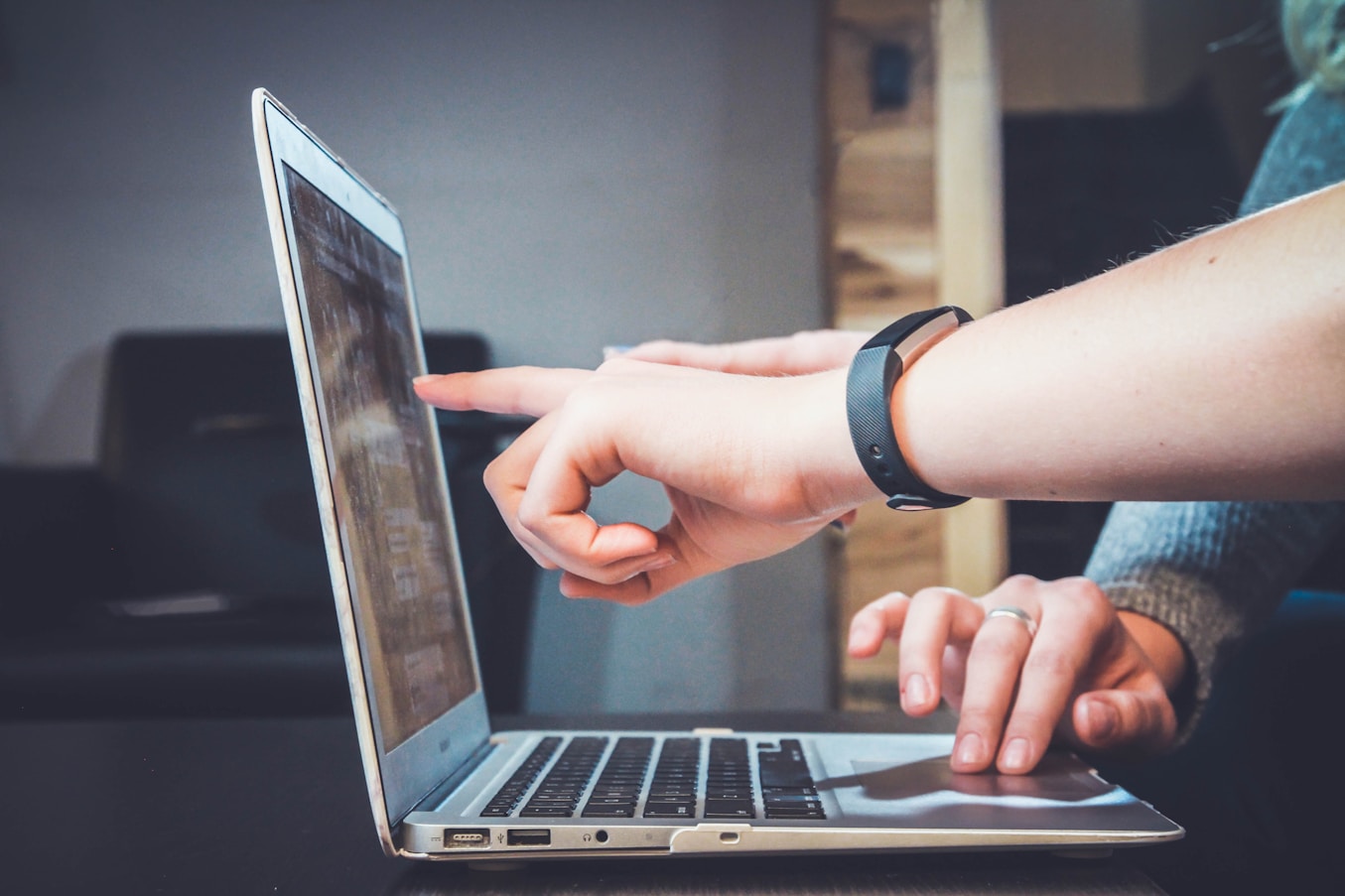 Two colleagues reviewing a product on a laptop together