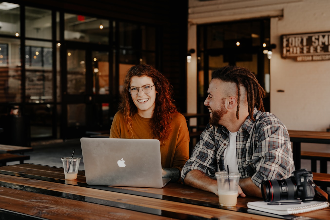 Two colleagues smiling while working together on a laptop