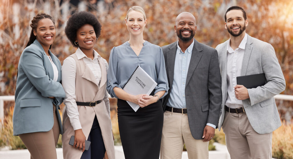 A diverse, confident team of professionals standing together outdoors